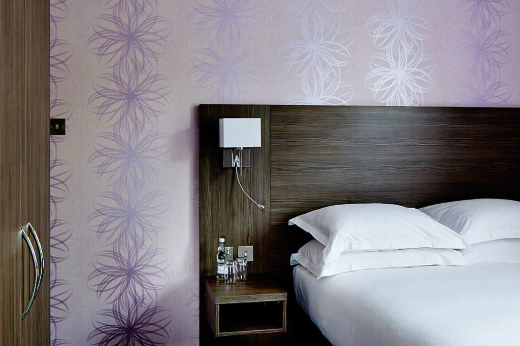 Bromley Court Hotel - A bed in a purple-walled room perfect for weddings or events.